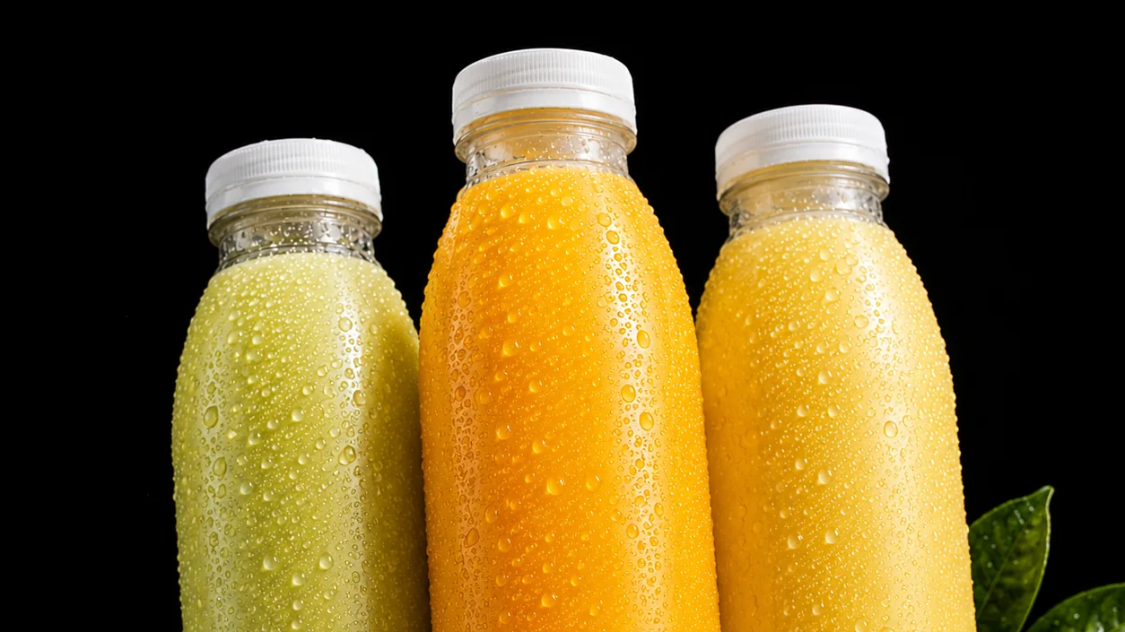 Three unlabelled bottles of fresh citrus juice